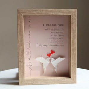 May include: A framed print with a pink background and white origami birds. The print features the text "I choose you and I'll choose you over and over without pause without a doubt in a heartbeat I'll keep choosing you". The date "08.08.2020" and the names "Amy & Edmund" are written in cursive on the side of the print.