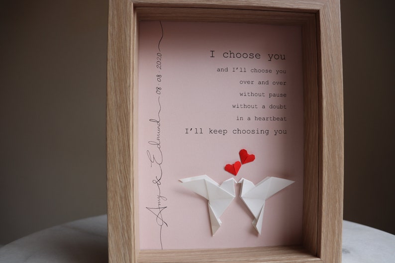 May include: A framed print with a pink background and white origami birds. The print features the text "I choose you and I'll choose you over and over without pause without a doubt in a heartbeat I'll keep choosing you". The date "08:08:2020" and the names "Amy & Edmund" are written in cursive at the top and bottom of the print.