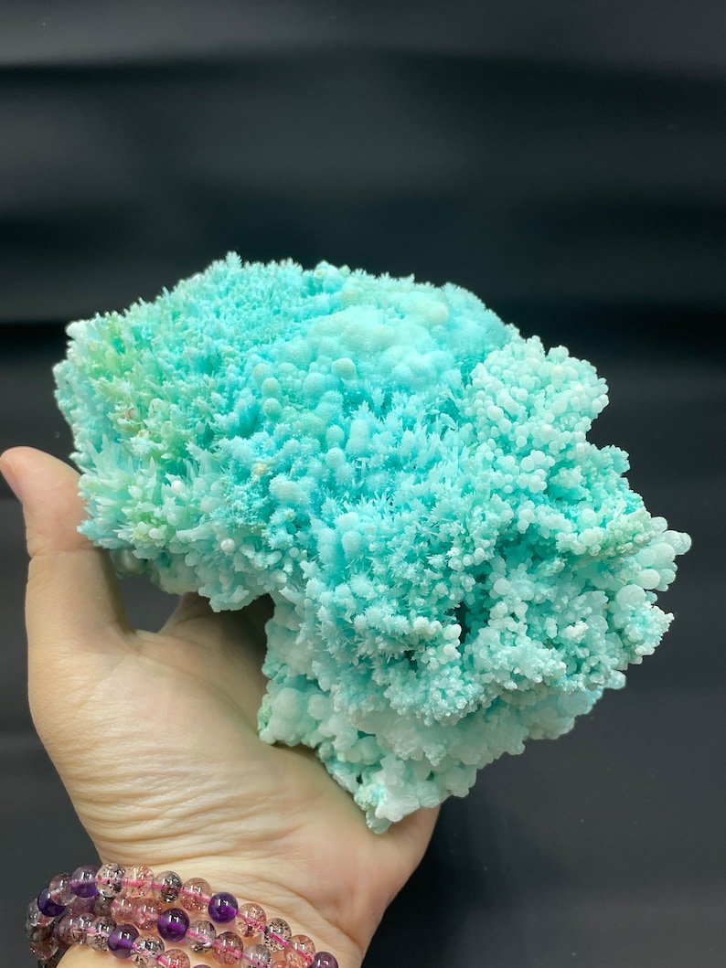 May include: A large, light blue, crystalline formation with a cauliflower-like texture. The formation is made of many small, delicate crystals.