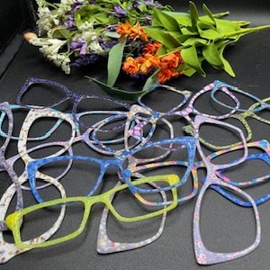Puede incluir: Una pila de gafas de colores con patrones con detalles azules, morados, verdes y blancos.