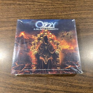 May include: A CD case featuring the text "Ozzy & Black Sabbath." The cover art depicts a hooded figure seated on a throne of skulls, with a fiery background. The text "Journey Through The Inner World Of Ozzy Osbourne And Black Sabbath" is also visible.