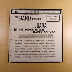 May include: A black and white record album cover with the title "The Band I Heard In Tijuana" and a list of 50 hit songs in that happy sound. The album cover features a red and white "Realistic" logo with the catalog number "50-1030".
