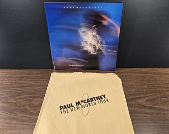 Libro de Paul McCartney: The New World Tour en su bolsa de papel original, 1993
