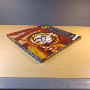 May include: A yellow and orange CD case with the text "The Band Heard In Tuliana" and "Cat No. 50-1030" printed on the spine.