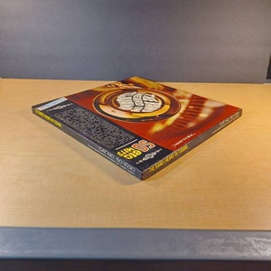 May include: A black and red record album cover with the text "50 Big Hits" and "The Band Heard In Tijuana" in white. The album cover features a gold trumpet with a red and white design.