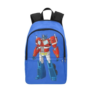 Puede incluir: Una mochila azul con una imagen de dibujos animados de Optimus Prime, un robot rojo y azul de la franquicia Transformers.