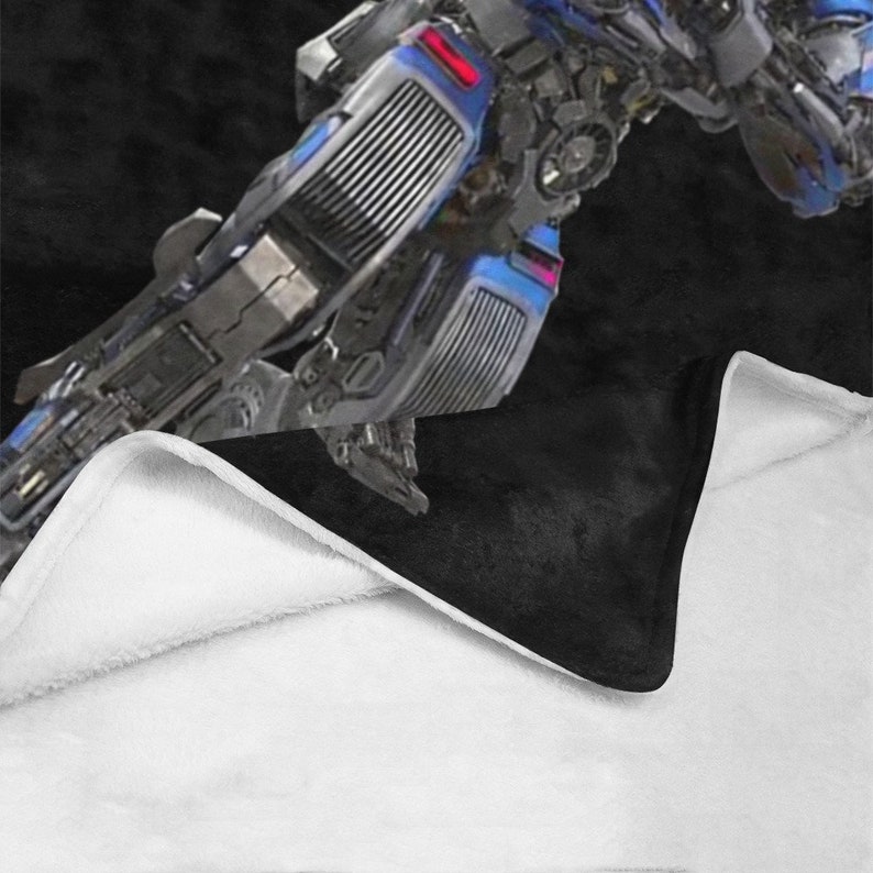 May include: A black and blue robot toy with a metallic finish. The robot is in a mid-air pose with one leg extended and the other leg bent. The robot has a detailed design with visible gears and other mechanical parts.