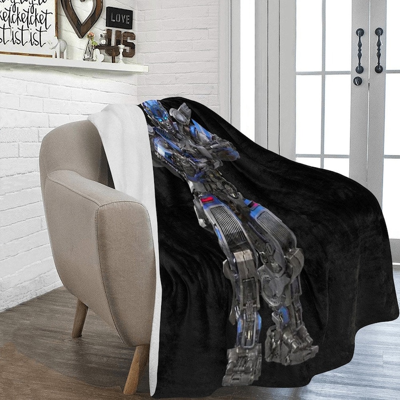 May include: A black and blue fleece throw blanket with a robot design. The robot is made of metal and has a blue and silver color scheme.