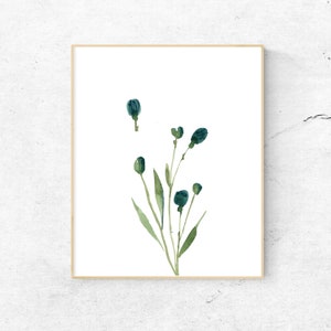 Puede incluir: Una pintura de acuarela de una rama de hojas verdes con capullos de flores azules. La pintura est&aacute; enmarcada en un marco de madera claro.