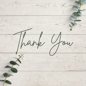 Puede incluir: Un fondo de madera blanca con el texto "Thank You" escrito en cursiva negra. Hay hojas de eucalipto verdes en las esquinas superior derecha e inferior izquierda de la imagen.