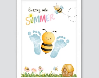May include: A framed print with a watercolor illustration featuring a bee design. The artwork includes the text "Buzzing into Summer" in colorful letters, a cartoon bee, and baby footprints. The image also includes a beehive and flowers.
