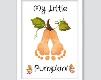 May include: A framed print featuring a pumpkin design made from baby footprints. The words "My Little Pumpkin!" are written in black script above and below the pumpkin illustration. The pumpkin is orange with green leaves.