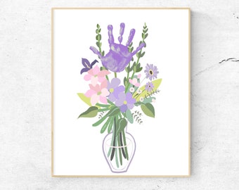 May include: A purple handprint surrounded by a bouquet of pink, purple, and white flowers in a clear glass vase. The flowers are arranged in a vase on a white background.