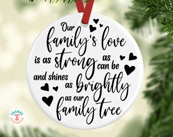 May include: White round Christmas ornament with black text that reads "Our family's love is as strong as can be and shines as brightly as our family tree".  The ornament is decorated with small black hearts.