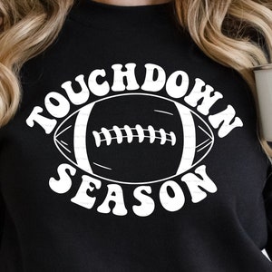 May include: Black sweatshirt with white text that reads "Touchdown Season" and a white outline of a football.