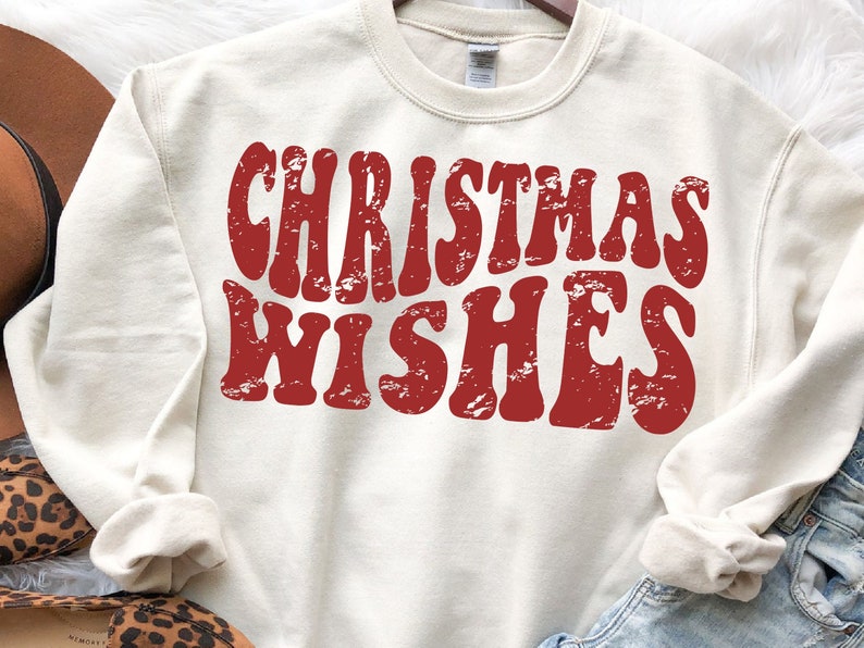 May include: A cream colored sweatshirt with a red vintage style graphic that says "Christmas Wishes".