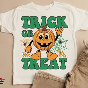 May include: White t-shirt with a green "Trick or Treat" graphic featuring a smiling pumpkin with a spiderweb behind it.