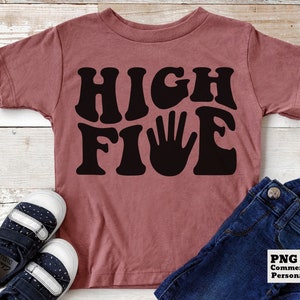 K&ouml;nnte beinhalten: Ein pinkfarbenes T-Shirt mit einer schwarzen Grafik, auf der in einer Retro-Schrift "HIGH FIVE" steht. Die Grafik enth&auml;lt einen schwarzen Handabdruck.