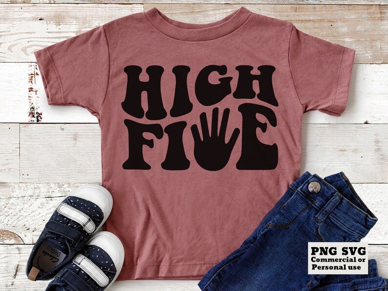 K&ouml;nnte beinhalten: Ein pinkfarbenes T-Shirt mit einer schwarzen Grafik, auf der in einer Retro-Schrift "HIGH FIVE" steht. Die Grafik enth&auml;lt einen schwarzen Handabdruck.