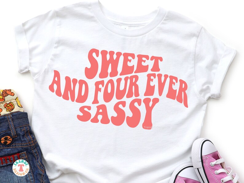 May include: White t-shirt with a pink graphic that says "Sweet and Four Ever Sassy" in a retro font.