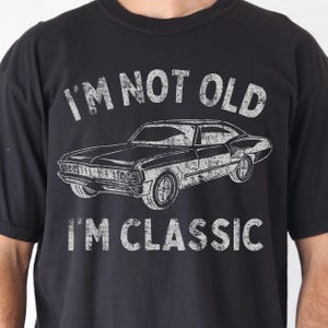 May include: Black t-shirt with a vintage-style graphic of a classic car and the text "I'm not old I'm classic".