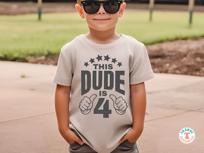 May include: A light gray t-shirt with a black graphic that says "This Dude is 4" with two thumbs up on either side of the number 4. The shirt has a row of five black stars above the text.
