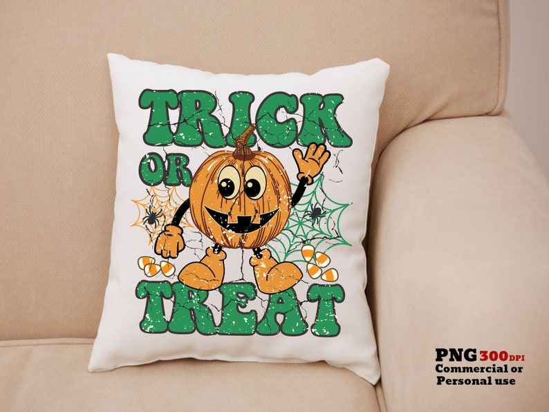 May include: A white pillow with a green and orange Halloween design. The design features a smiling pumpkin with a spider web and the text "Trick or Treat".