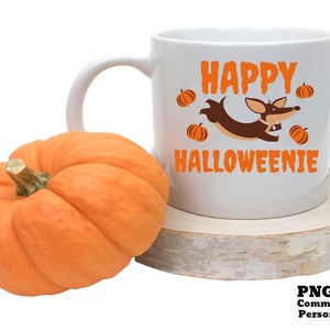 May include: White ceramic coffee mug with a brown dachshund dog wearing a pumpkin hat and the text "Happy Halloweenie" in orange letters. The mug is sitting on a wooden coaster.