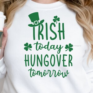 May include: White sweatshirt with green shamrock and leprechaun hat graphic. The text reads "Irish today, hangover tomorrow".