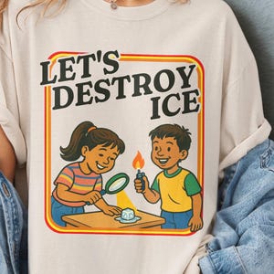 May include: Ivory Comfort Colors t-shirt with the text "LET'S DESTROY ICE" and a graphic of two children experimenting with ice. The shirt has a retro design and is available in multiple colors. The shirt is part of the Mind & Harmony Gifts collection.