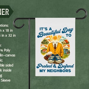 May include: A white garden flag with the text "It's a Beautiful Day to Protect & Defend My Neighbors." The flag features a cartoon illustration of a person's outfit and a neighborhood scene. The flag is displayed on a black metal stand.