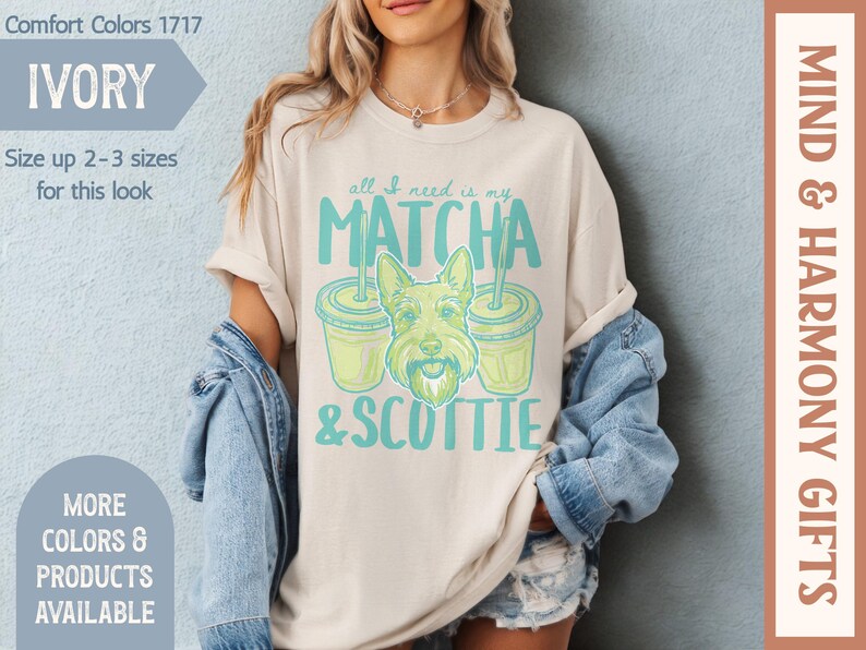 May include: Ivory-colored t-shirt with the text "all I need is my MATCHA & SCOTTIE" in teal. The graphic includes a cartoon Scottie dog and two matcha drinks. The shirt is part of the Comfort Colors 1717 collection.