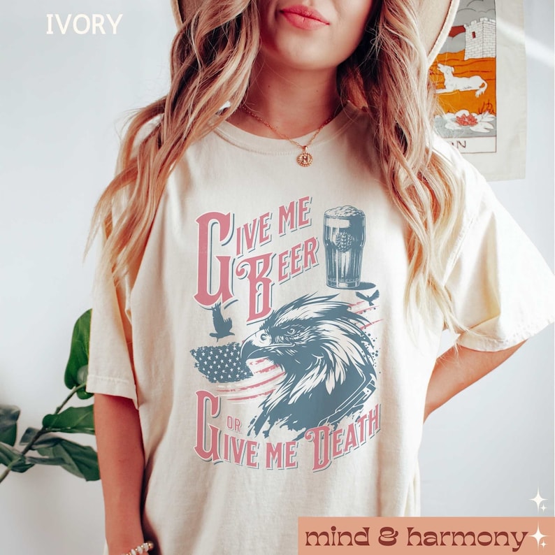 Peut inclure: Un t-shirt cr&egrave;me avec un graphique de style vintage repr&eacute;sentant un aigle, un drapeau am&eacute;ricain et le texte "Give Me Beer Or Give Me Death".
