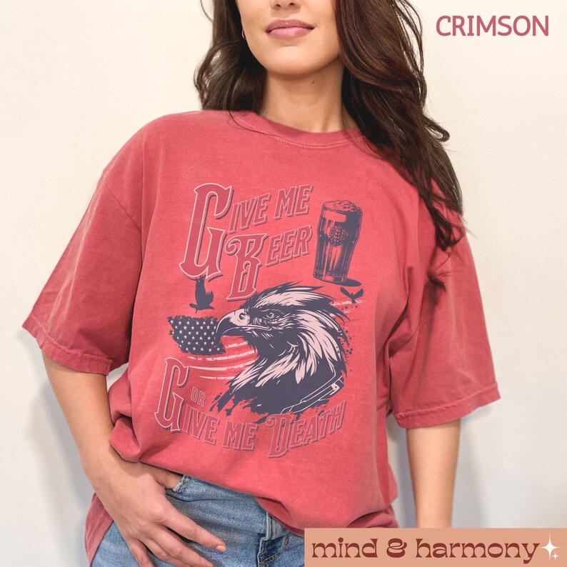 Peut inclure: Un t-shirt rouge &agrave; l'aspect vieilli avec un graphique d'un aigle sur fond de drapeau am&eacute;ricain. Le texte sur le t-shirt est "Give Me Beer Or Give Me Death".