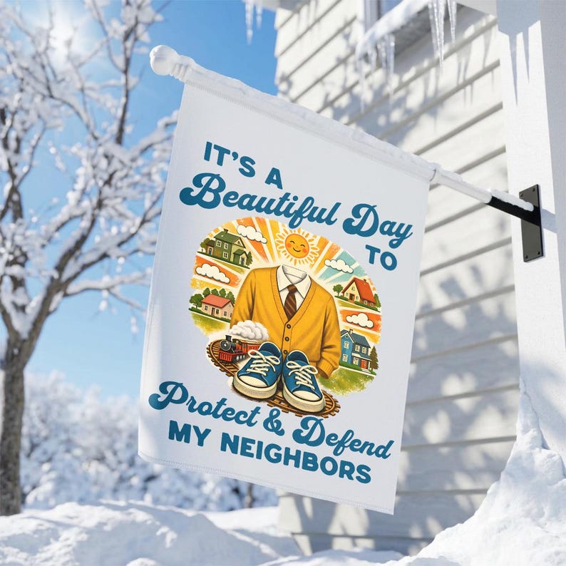 May include: White flag with the text "IT'S A Beautiful Day to Protect & Defend MY NEIGHBORS". The flag features a cartoon illustration of a headless figure wearing a yellow sweater and blue sneakers, with houses and a train in the background.