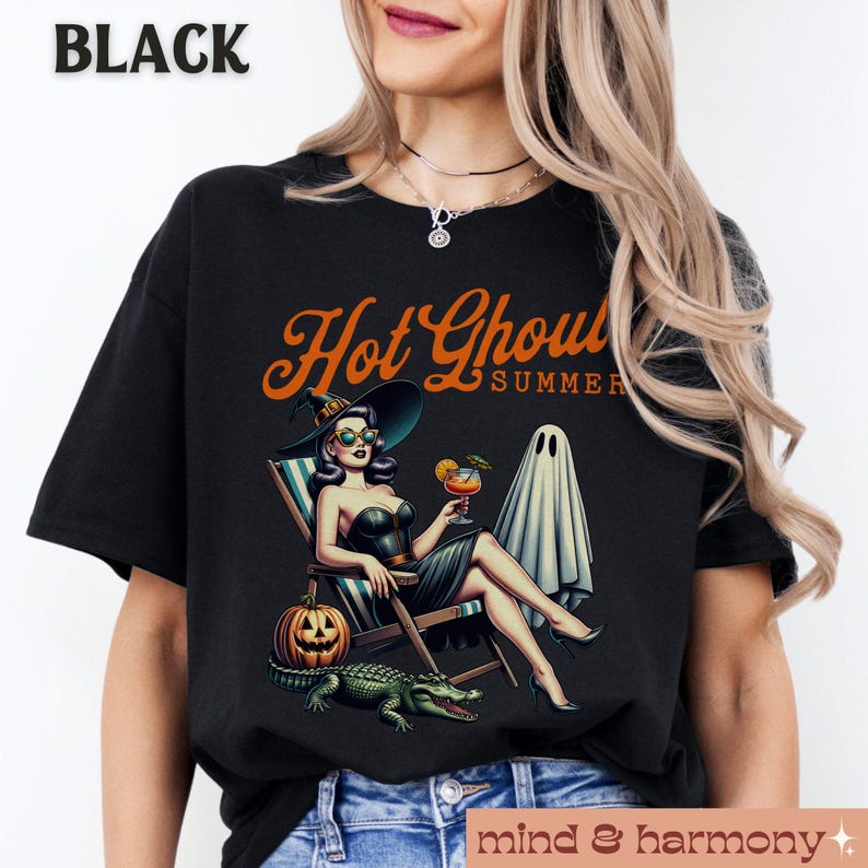 Pu&ograve; includere: T-shirt nero con grafica retr&ograve;. Il design mostra una donna con cappello da strega e occhiali da sole, che si rilassa su una sedia a sdraio con un cocktail, un fantasma, una zucca e un alligatore. Il testo "Hot Ghoul Summer" &egrave; sopra.