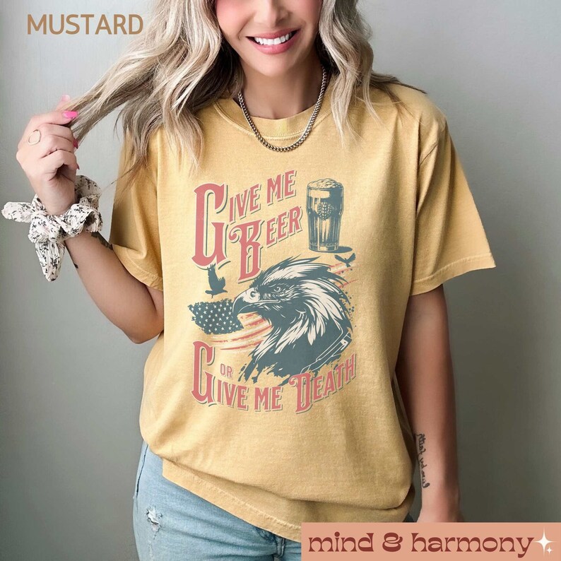 Peut inclure: Un t-shirt jaune moutarde &agrave; l'aspect vintage d&eacute;lav&eacute; avec un graphique d'un aigle tenant un verre de bi&egrave;re avec le texte "Give Me Beer Or Give Me Death".