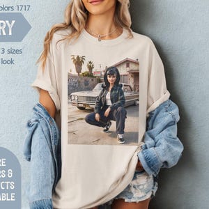 May include: Ivory Comfort Colors t-shirt featuring a graphic of a person in front of a car. The shirt has the text "Size up 2-3 sizes for this look". Additional text includes "More Colors & Products Available" and "Mind & Harmony Gifts".