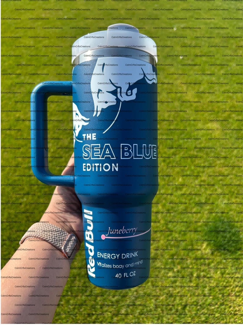 Pu&ograve; includere: Un bicchiere blu isolato con manico, con la scritta "THE SEA BLUE EDITION" e un logo Red Bull. Il bicchiere mostra anche "Juneberry" e "ENERGY DRINK" con una capacit&agrave; di 1,18 litri.