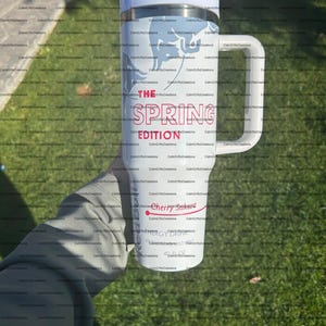 Pu&ograve; includere: Un bicchiere da viaggio bianco con manico, con la scritta "THE SPRING EDITION" in rosso e un logo "Cherry Sakura". Il bicchiere ha un design azzurro e contiene circa 1,18 litri.