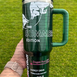 Pu&ograve; includere: Tazza termica verde con manico, con la scritta "THE SUMMER EDITION" e una grafica bianca. La tazza presenta anche "Dragon Fruit" e "ENERGY DRINK" con una capacit&agrave; di 1,18 litri.