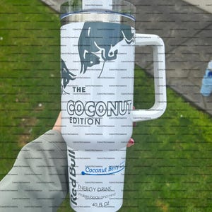 Pu&ograve; includere: Un bicchiere termico bianco con manico, con logo Red Bull e testo. Il bicchiere recita "THE COCONUT EDITION" e "Coconut Berry ENERGY DRINK" con una capacit&agrave; di 1,18 litri.