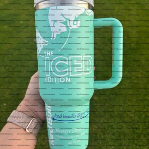 Pu&ograve; includere: Un grande bicchiere isolante verde acqua con manico, con testo bianco che recita "THE ICED EDITION" e "Iced Vanilla Berry". Il bicchiere ha anche un bordo argentato e un coperchio bianco. &Egrave; progettato per contenere 1,18 litri di liquido.