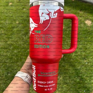 Pu&ograve; includere: Un bicchiere termico rosso con manico, con il logo Red Bull e la scritta "THE RED EDITION". Mostra anche "Watermelon" e "ENERGY DRINK" con una capacit&agrave; di 1,18 litri.