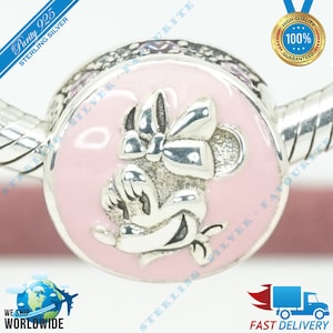 May include: Sterling silver charm featuring a pink enamel background with a silver Minnie Mouse design. The charm is attached to a silver bracelet.