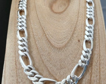 May include: A silver chain necklace with a curb link design. The chain is thick and has a polished finish.