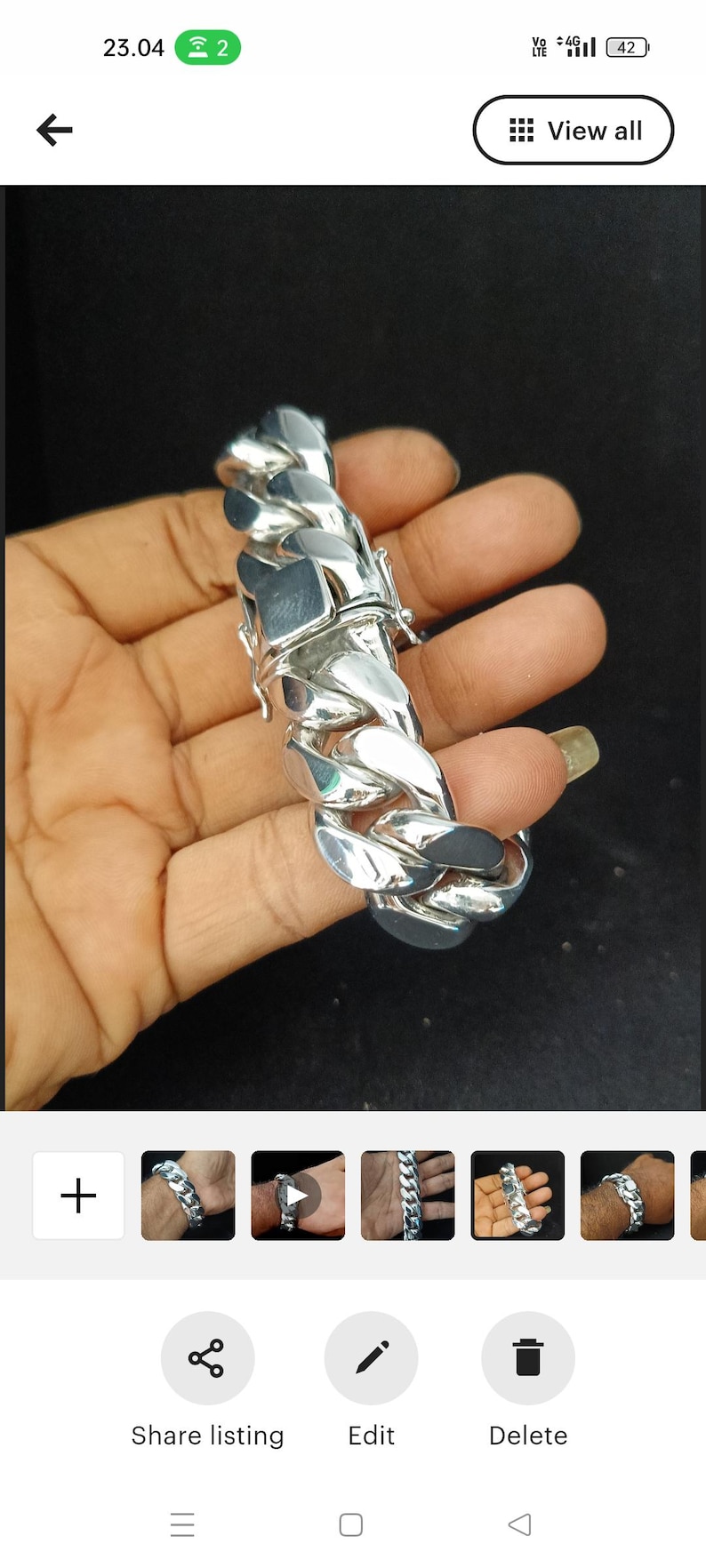 May include: A silver curb chain bracelet with a clasp closure. The bracelet is thick and chunky, with a large, bold design.