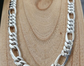May include: A silver chain necklace with a curb link design. The chain is thick and has a polished finish.