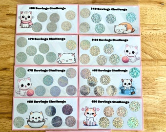 May include: Ten pink cards with a savings challenge theme. Each card features a different amount from £50 to £120, with a cute cartoon cat illustration. The cards are decorated with glitter.