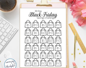Puede incluir: Un imprimible del Desafío de Ahorro del Black Friday de 30 días en un portapapeles. El diseño presenta ilustraciones de bolsas de la compra con cantidades en dólares. El texto "30 Day Black Friday Savings Challenge" está en la parte superior. La imagen incluye una taza de café, material de oficina y flores.